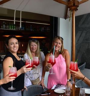 a group of women holding up wine glasses