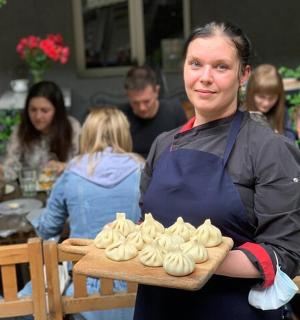 a woman holding a tray of cupcakes