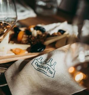 a table with a glass of wine and a plate of food