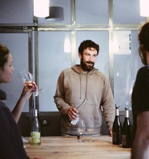 一群人围着桌子站着，手里拿着酒杯