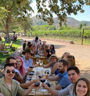 一群人坐在桌边，手里拿着酒杯