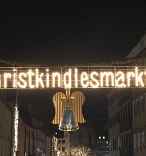 a sign for a christmasmas market with a bell