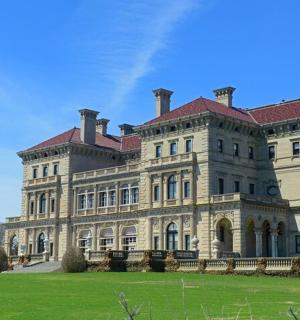 a large stone building with a grass field in front