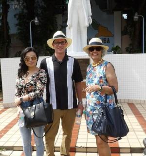 a man and two women standing in front of a statue
