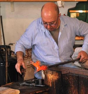 一名男子在桌子上切割一块金属