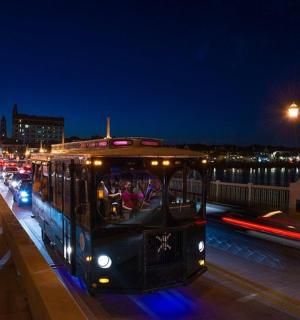 eine Straßenbahn auf einer Stadtstraße bei Nacht