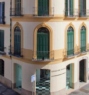 a building with green doors and balconies on a street