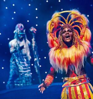 a woman is singing in a performance on a stage