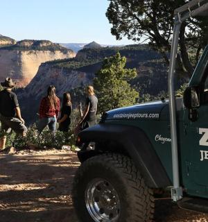 一群人站在一辆绿色吉普车旁边