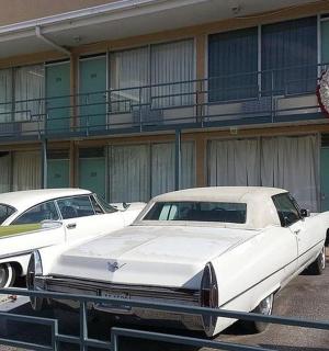 dvě bílá auta zaparkovaná před budovou