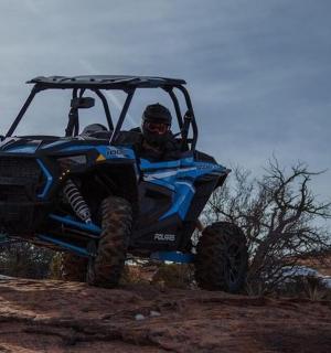 a person riding in a atv on a hill