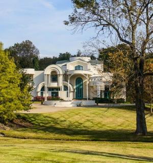 velký bílý dům se stromem před ním