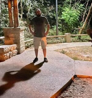 一名男子站在人行道上,身后有阴影