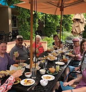 skupina lidí sedících u stolu a jedících