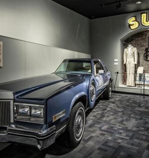 a blue car is on display in a museum