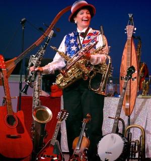 muž hrající na saxofon a další nástroje na pódiu