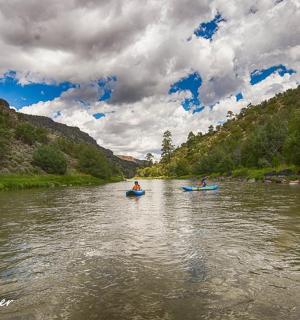 dva lidé v kajacích na řece za zamračeného dne