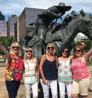 a group of women standing in front of a statue
