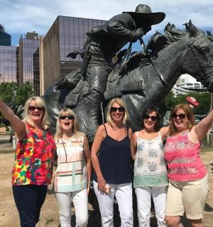 a group of women standing in front of a statue