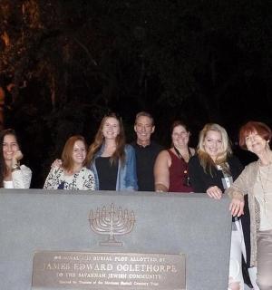 a group of people standing behind a sign