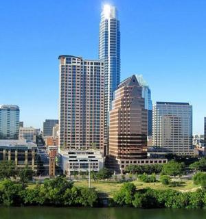 a city skyline with tall buildings and a river