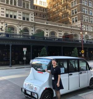 žena stojící vedle malého auta na ulici