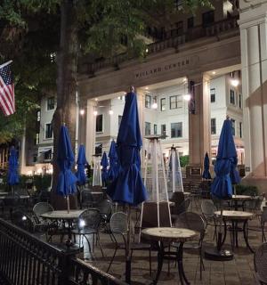 Skupina stolů a židlí s modrými slunečníky