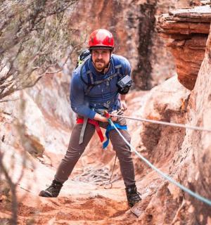 a man is on a rope in a canyon