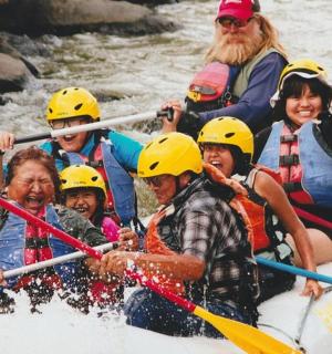 skupina lidí sjíždějících řeku na raftech