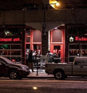 two cars parked in front of a restaurant at night