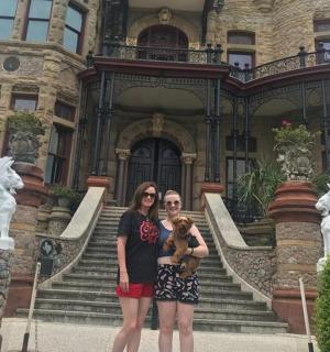 一对母女站在一座豪宅前