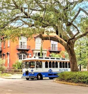 a blue and white bus parked in front of a building