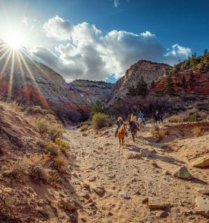 一群人骑马沿着土路前行