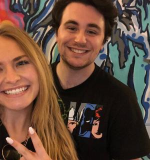 a man and a woman standing in front of a mural