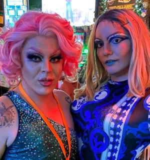 two women standing next to each other in a bar