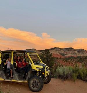 Skupina lidí jedoucích v džípu v poušti