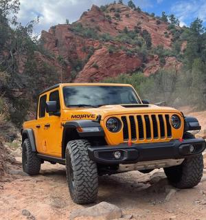 一辆黄色吉普车停在一条土路上