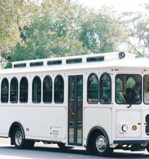 bílý autobus jede po ulici