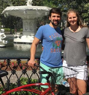 a man and a woman standing in front of a fountain