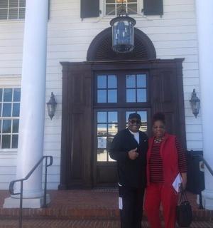 a man and a woman standing in front of a house