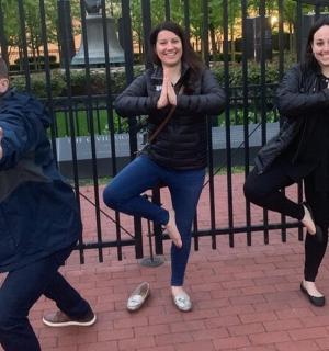 skupina tří lidí stojící u plotu