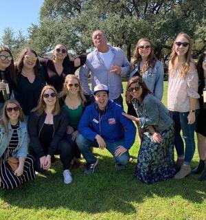 a group of people posing for a picture in the grass