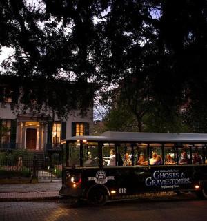 a trolley full of people driving down a street