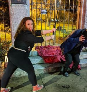 two people standing on steps in front of a fence