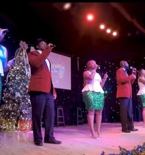 skupina lidí zpívajících na pódiu