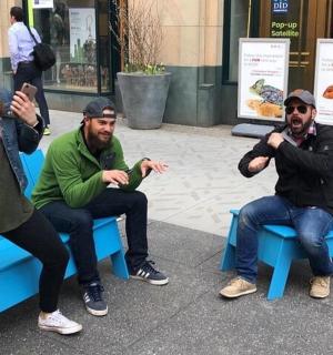 a group of people sitting on a blue bench