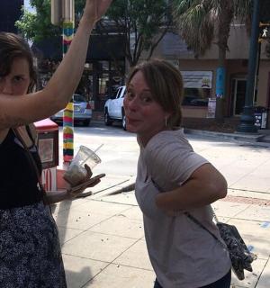 dvě ženy stojící na chodníku s paží ve vzduchu