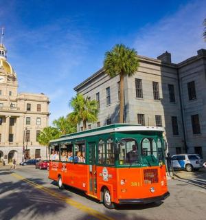 oranžový a zelený autobus jedoucí po městské ulici