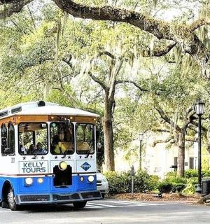 a blue and white bus driving down a street