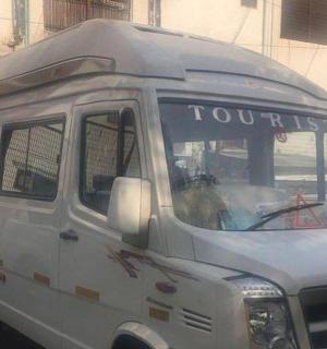 一辆白色面包车，车头上写着“tour”